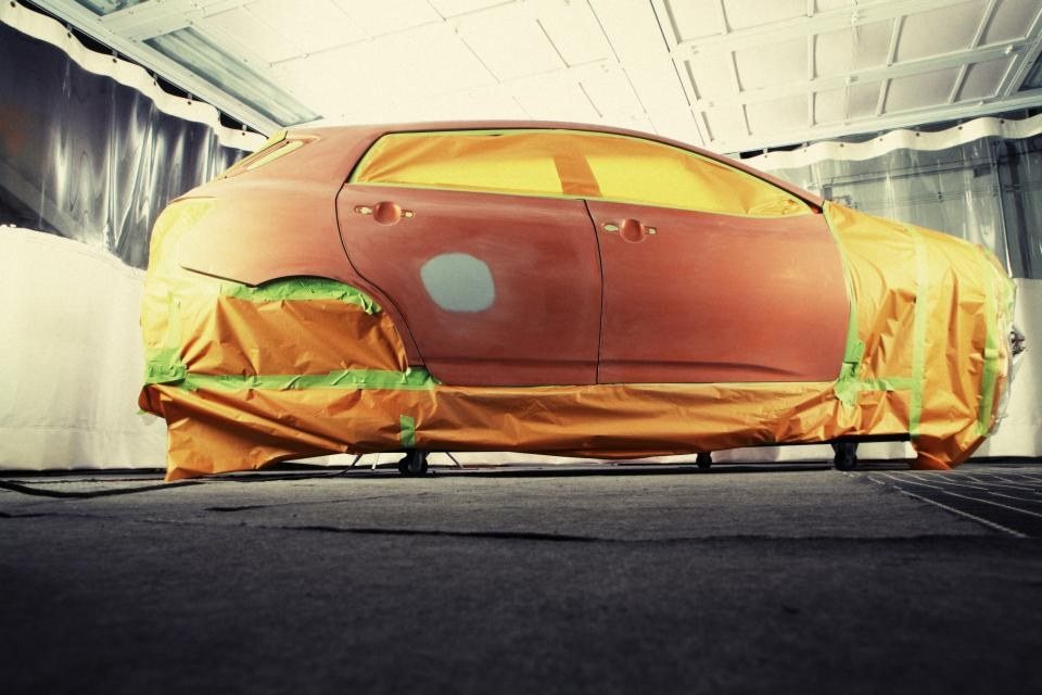 Car masked and prepped for paint in a booth